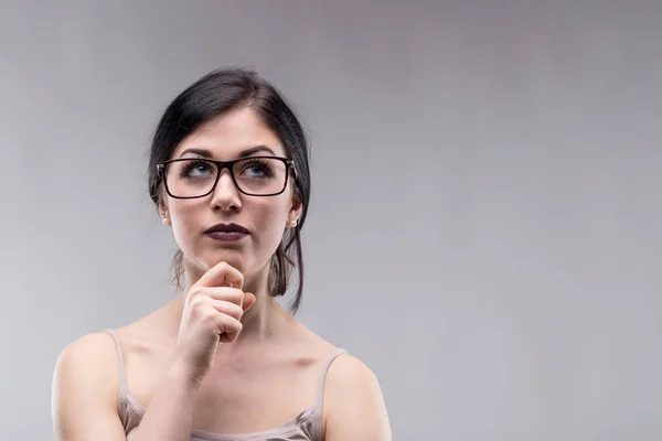 Attractive woman in glasses deep in thought — Stock Photo, Image