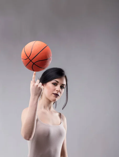 Atractiva mujer deportiva equilibrando un baloncesto —  Fotos de Stock