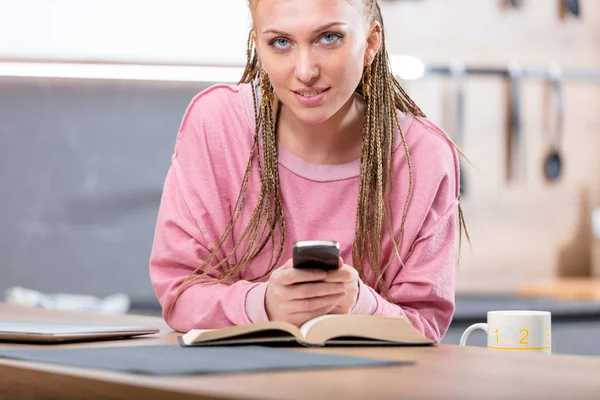 Attractive young blond woman holding a smartphone — Stock Photo, Image