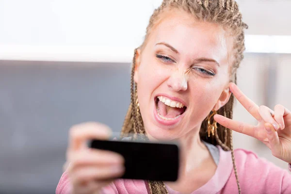 Young woman cheering as she takes a selfie — Stock Photo, Image