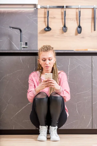 Serious trendy young woman using her mobile — Stock Photo, Image