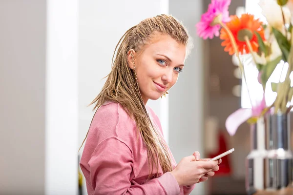 Smiling friendly young woman using a mobile — Stock Photo, Image