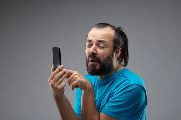 Bearded Man Squinting Grimace Touching Smartphone Screen Holding Phone Front — Stock Photo, Image