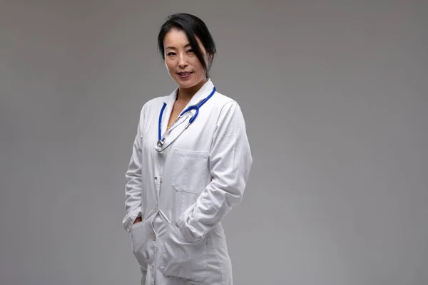 Friendly Asian Doctor Nurse Confident Smile Standing Her Hands Pockets — Stock Photo, Image