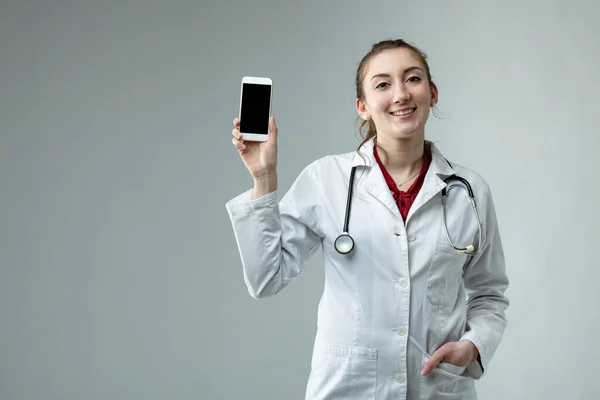 Médica Mulher Sorridente Jaleco Branco Estetoscópio Segurando Telefone Celular Com — Fotografia de Stock