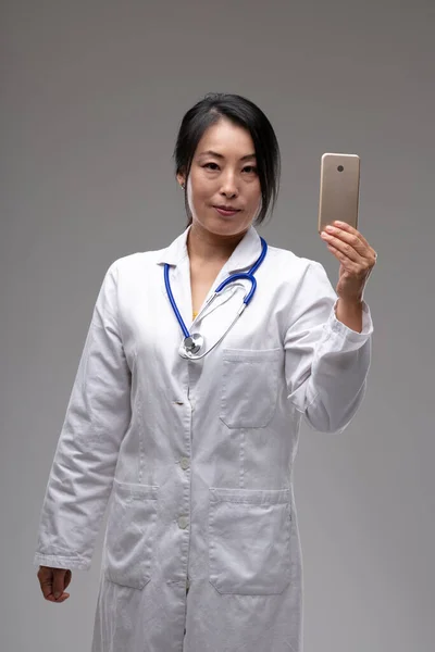 Asiática Médico Mulher Estetoscópio Jaleco Branco Segurando Telefone Celular Como — Fotografia de Stock