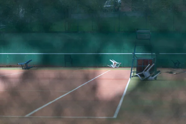 Deserted Tennis Court Upturned Chairs Viewed Hole Fence Empty Due — Stock Photo, Image