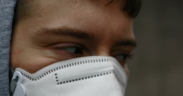 Ragazzo a piedi in una città ostile con una maschera — Video Stock