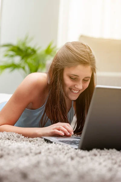 Sorrindo Jovem Adolescente Trabalhando Laptop Enquanto Ela Relaxa Tapete Sala — Fotografia de Stock