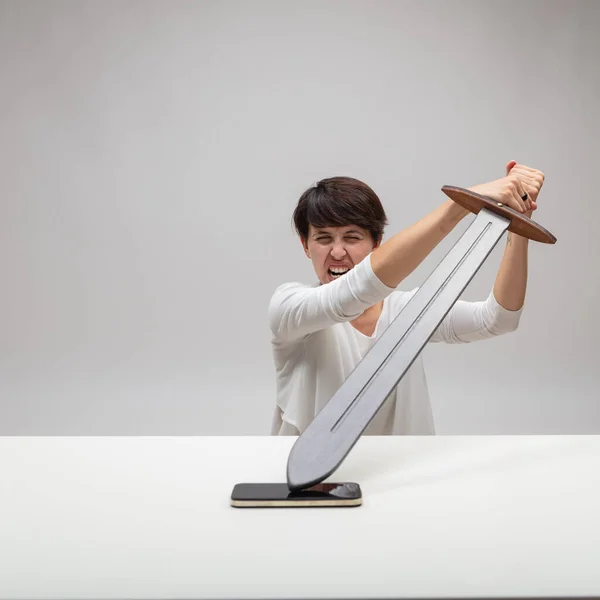 Angry Woman Attacking Her Mobile Phone Large Toy Sword Exasperated — Stock Photo, Image