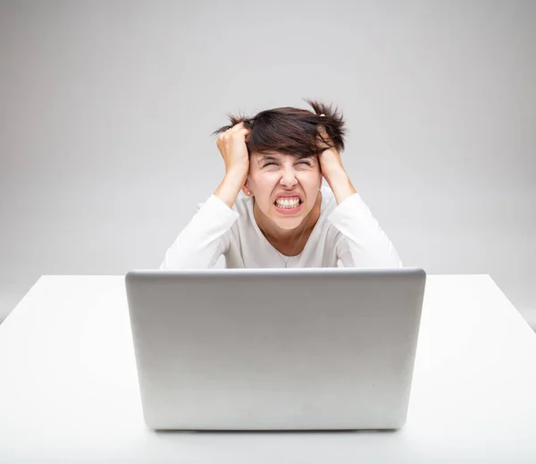 Sinirli Bir Kadını Gri Bir Arka Planda Dizüstü Bilgisayarın Başında — Stok fotoğraf