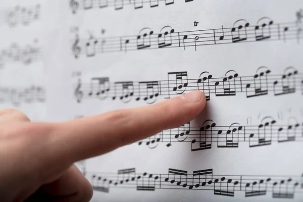 Vrouwelijke Vinger Noten Een Klassieke Muziekpartituur Een Close Full Frame — Stockfoto