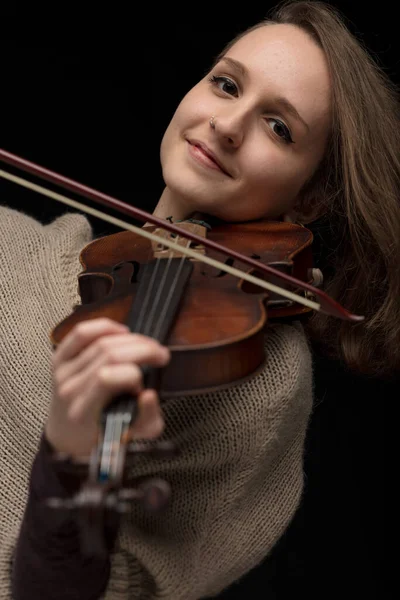 笑着的女小提琴家喜欢在一张特写的肖像画中演奏古典巴洛克小提琴 在黑色背景下聚焦于她的脸 — 图库照片