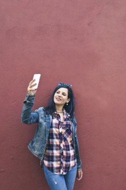 Kırmızı duvarında bir selfie haline genç kadın