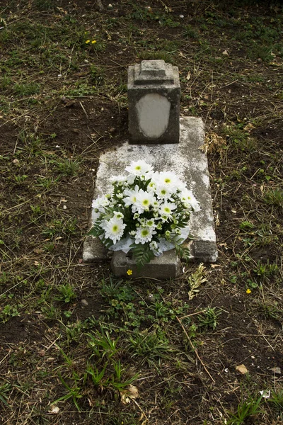 Tombe dans le cimetière avec bouquet de fleurs — Photo