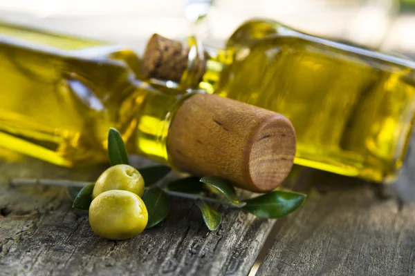 Azeitonas e garrafas de azeite em vintage de madeira — Fotografia de Stock