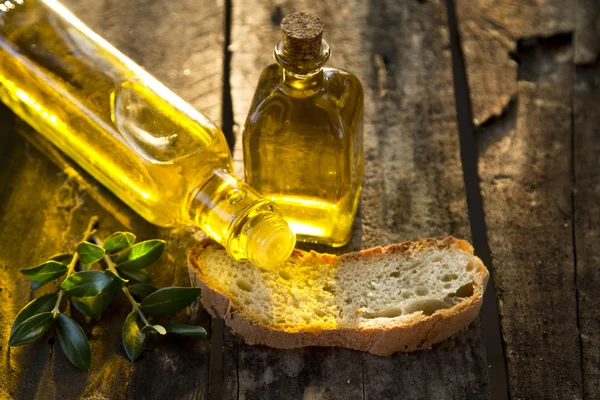 Botellas de aceite de oliva y pan rústico en rodajas — Foto de Stock