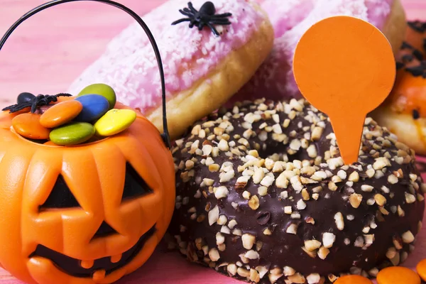 Halloween cukierki i słodycze na różowym tle — Zdjęcie stockowe