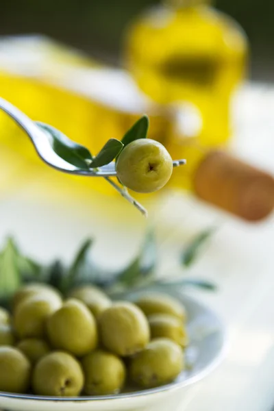 Оливка на вилке с зеленым фоном — стоковое фото