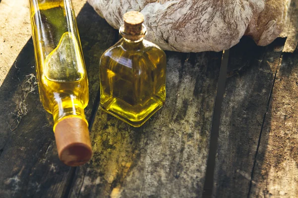 Bottles of olive oil and sliced rustic bread — Stock Photo, Image