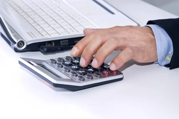 Руки бизнесмена в офисе с калькулятором — стоковое фото