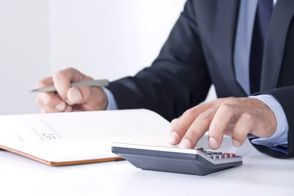 Hands of businessman in the office with calculator — Stock Photo, Image