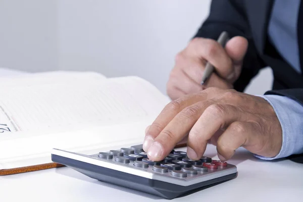 Hands of businessman in the office with calculator — Stock Photo, Image