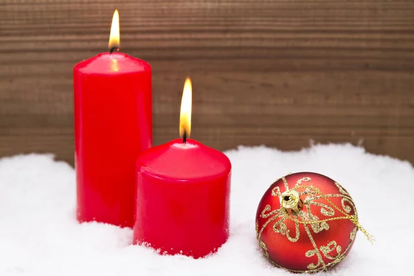 Bougies dans la neige avec des décorations de Noël — Photo