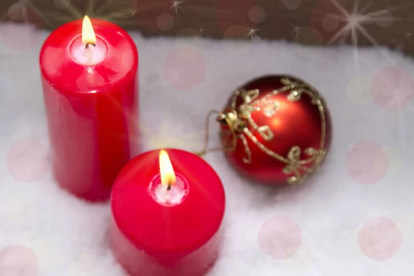 Lit candles on snowflakes with wooden background — Stock Photo, Image