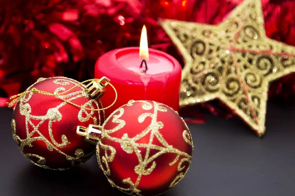 Candles on wooden Christmas decorations and red tinsel Royalty Free Stock Images