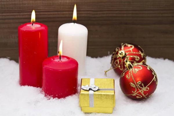 Tarjeta de Navidad con velas y decoraciones navideñas en la nieve —  Fotos de Stock