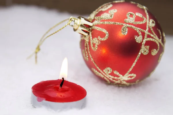Weihnachtskarte mit Kerze und Weihnachtskugeln im Schnee — Stockfoto