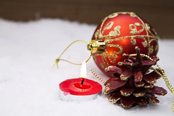 Kaart van Kerstmis met kaars en ballen van kerst in de sneeuw — Stockfoto