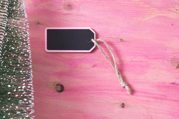 Albero di Natale su sfondo rosa in legno con etichetta — Foto Stock