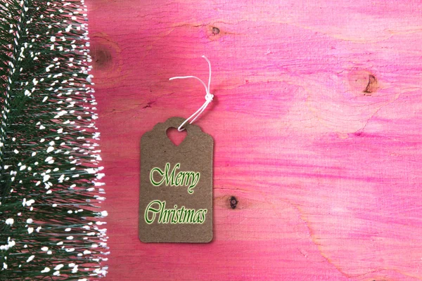 Árbol de Navidad sobre fondo de madera rosa con etiqueta —  Fotos de Stock