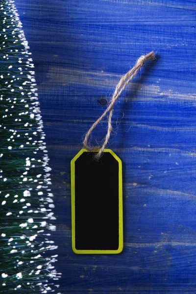 Рождественская елка на синем фоне с этикеткой — стоковое фото