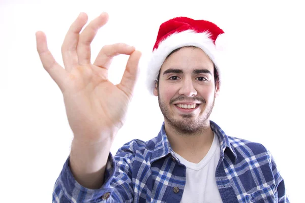 Männlich jung mit Hut des Weihnachtsmannes tut Zeichen von ok — Stockfoto