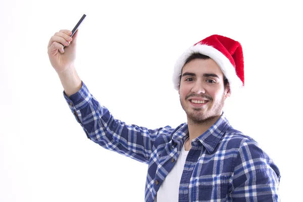 Junger Mann mit Weihnachtsmannhut wird zum Selfie mit dem Handy — Stockfoto