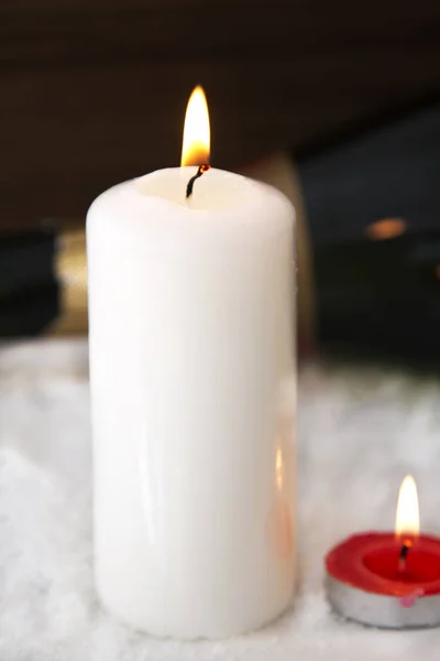 Christmas card with candles and bottle of champagne on snow — Stock Photo, Image