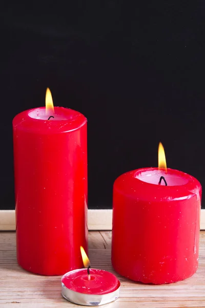 Blackboard tinsel and red  candles — Stock Photo, Image