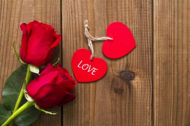 Romantik iletisi ve ahşap arka plan üzerinde kırmızı gül ile etiket