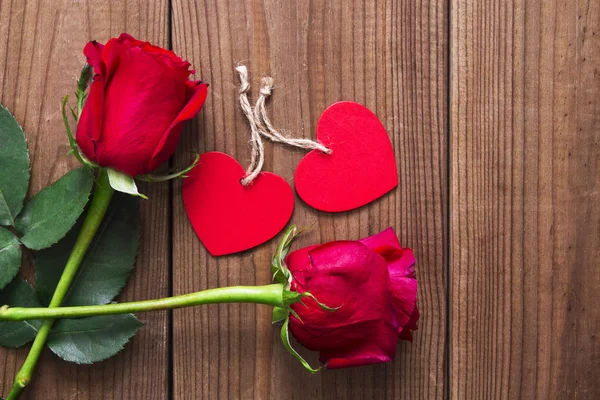 Label and red roses on wooden background — Stock Photo, Image