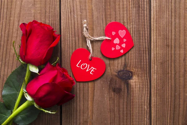 Romantik iletisi ve ahşap arka plan üzerinde kırmızı gül ile etiket
