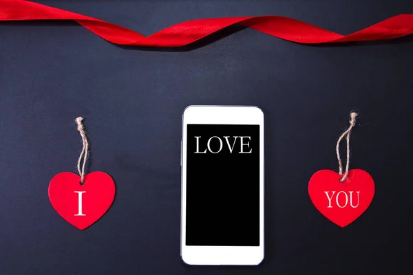 Mobilní telefon za popisky s poselstvím valentinky — Stock fotografie