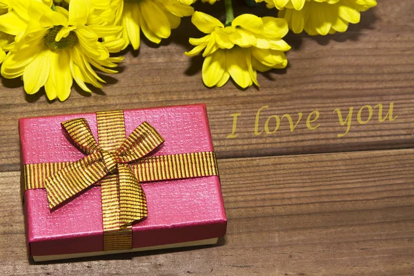 Confezione regalo e fiori gialli — Foto Stock