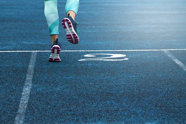 Mujer corriendo en pista azul — Foto de Stock