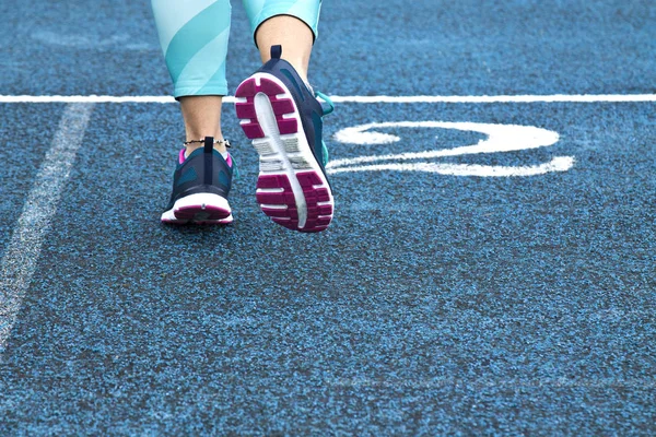 Mujer corriendo en pista azul — Foto de Stock