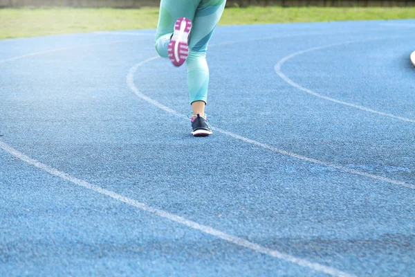 Mujer corriendo en la pista — Foto de Stock