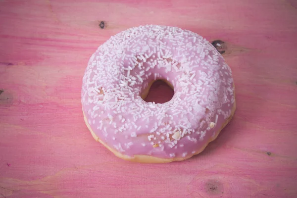 Donut em fundo de madeira rosa — Fotografia de Stock