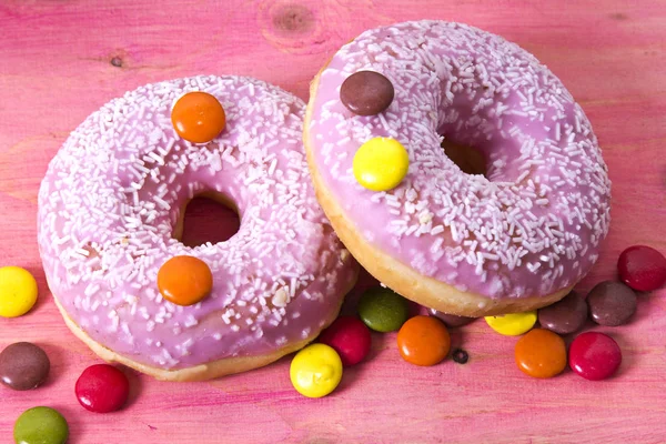 Coleção de donuts coloridos em rosa de madeira — Fotografia de Stock